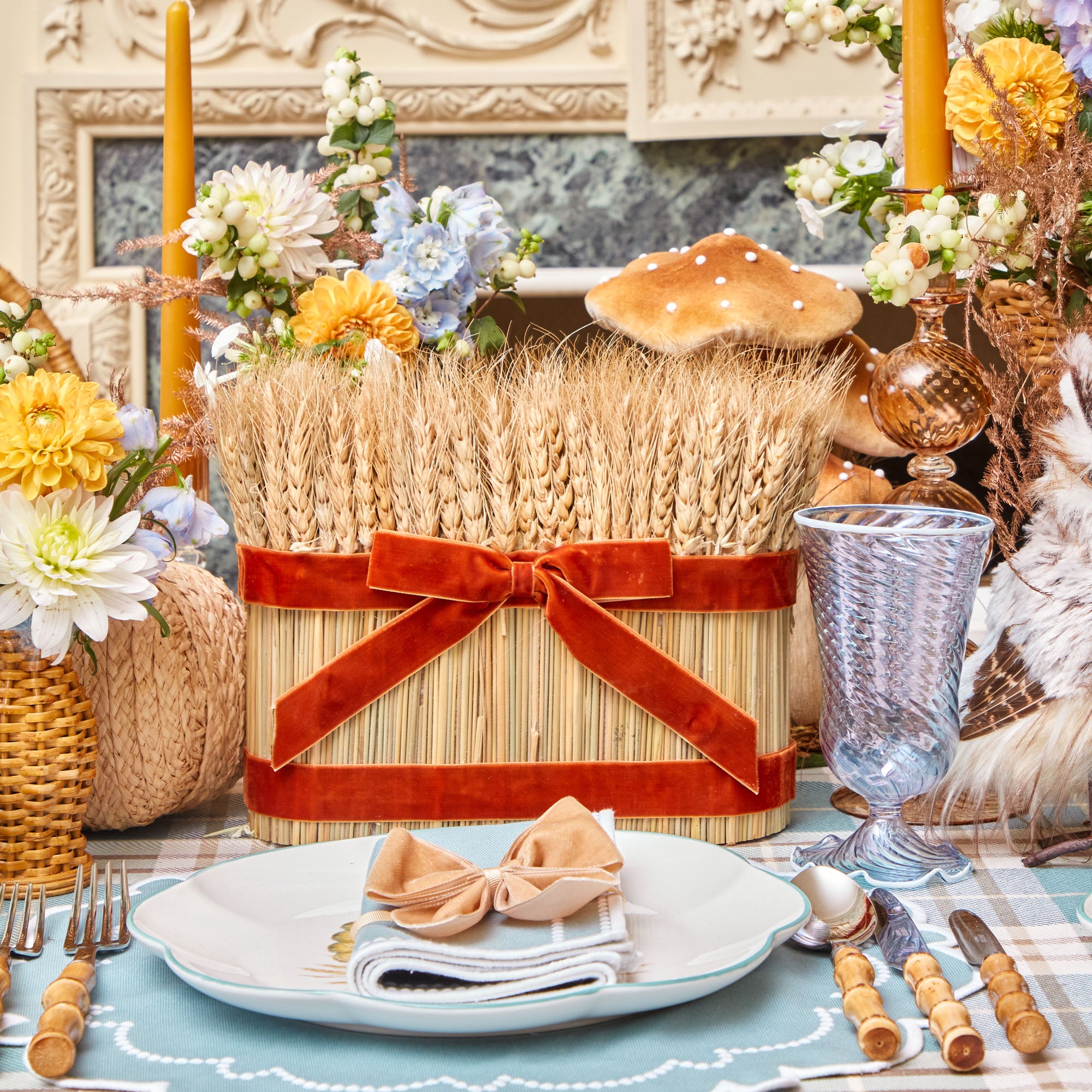 Long arrangement of wheat adorned with a velvet bow.